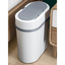 Modern smart touchless trash can with lid, placed beside wooden furniture on a hardwood floor